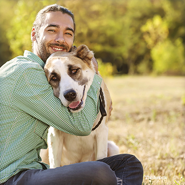 Pet parent hugging his dog