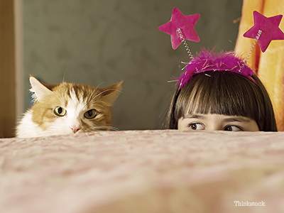 Cat and little girl playing together