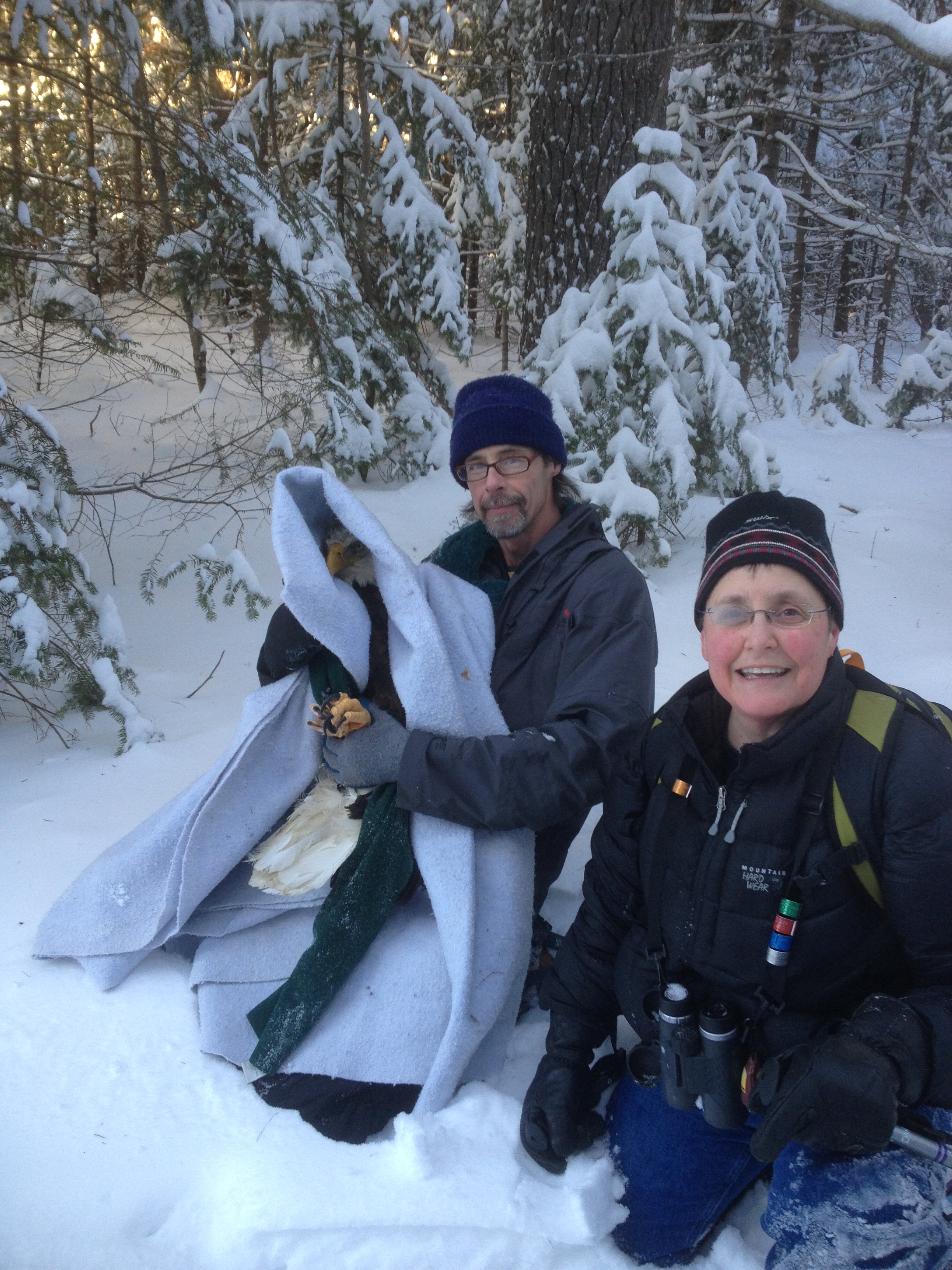 2 people and an eagle in the snow