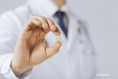 Veterinarian holding a fish oil pill