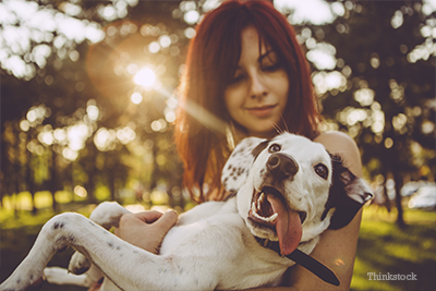 Woman holding dog outside