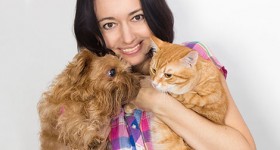 Woman holding a cat and a dog