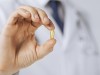 Veterinarian holding a fish oil pill