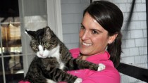 Woman holding reluctant cat