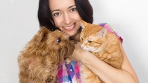 Woman holding a cat and a dog
