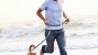 Man running on the beach with his dog