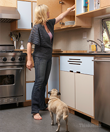 Woman reaching up high with dog watching